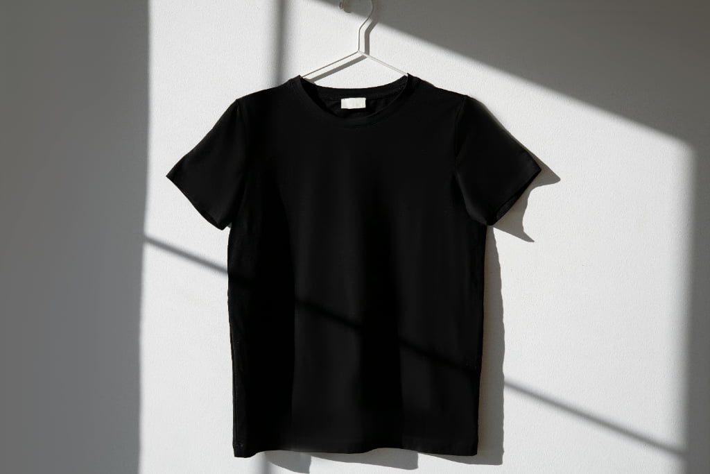 Collection of oversized t-shirts displayed on hangers showing various streetwear design styles including minimalist logos and bold graphic prints