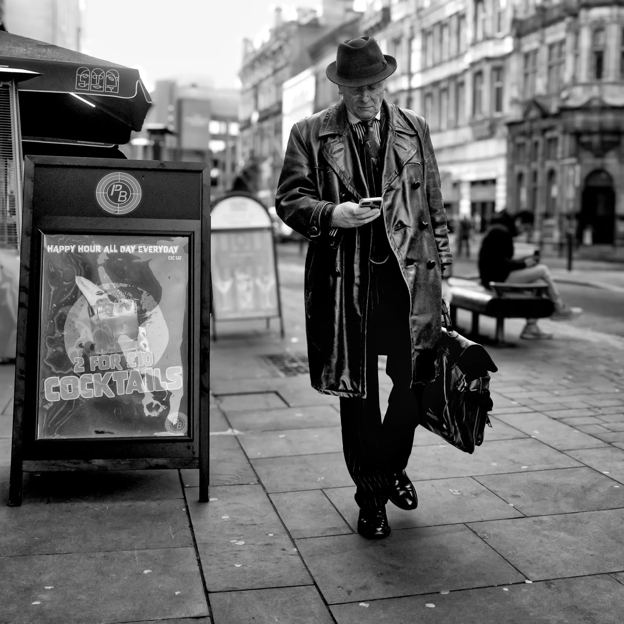 Black-and-white street portrait demonstrating strong composition with dramatic lighting and subject gaze directly engaging the viewer
