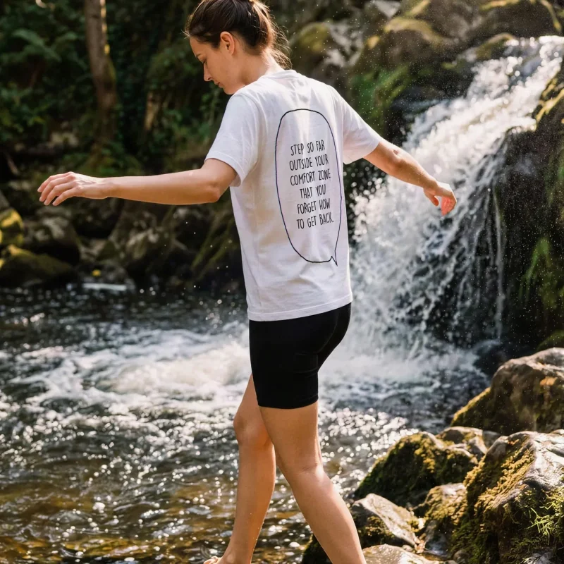 "Step outside your comfort zone & forget how to get back." Backprint Tee worn by a model
