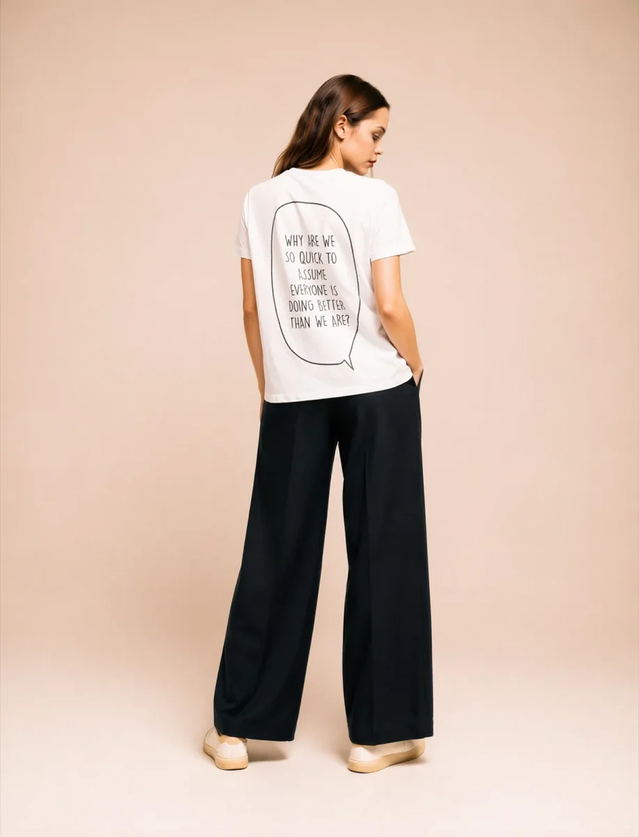 "WHY ARE WE SO QUICK TO ASSUME EVERYONE IS DOING BETTER THAN WE ARE?" Backprint Tee, back view, Its.That.
