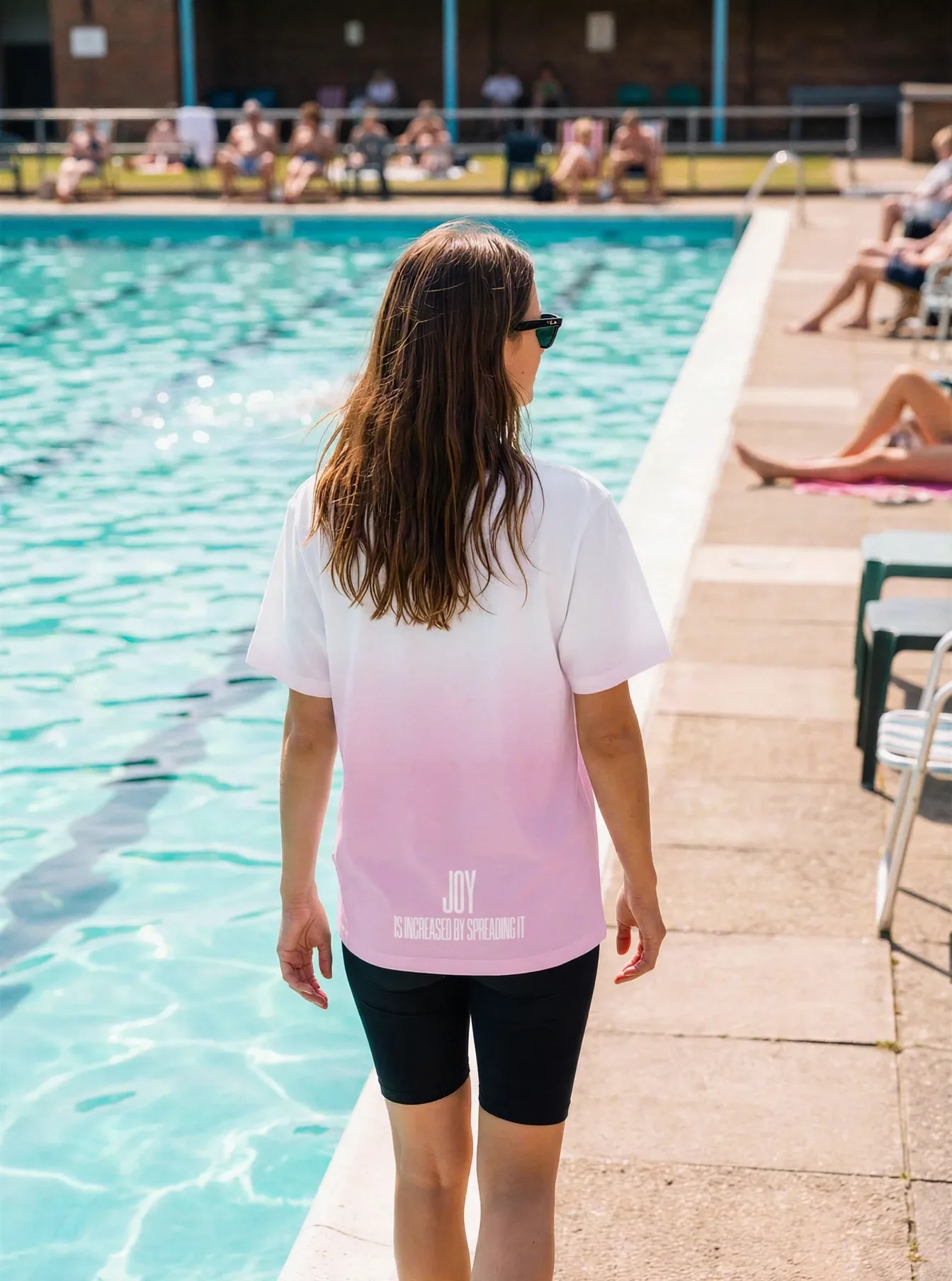 "JOY IS INCREASED BY SPREADING IT" Backprint Tee worn by a model