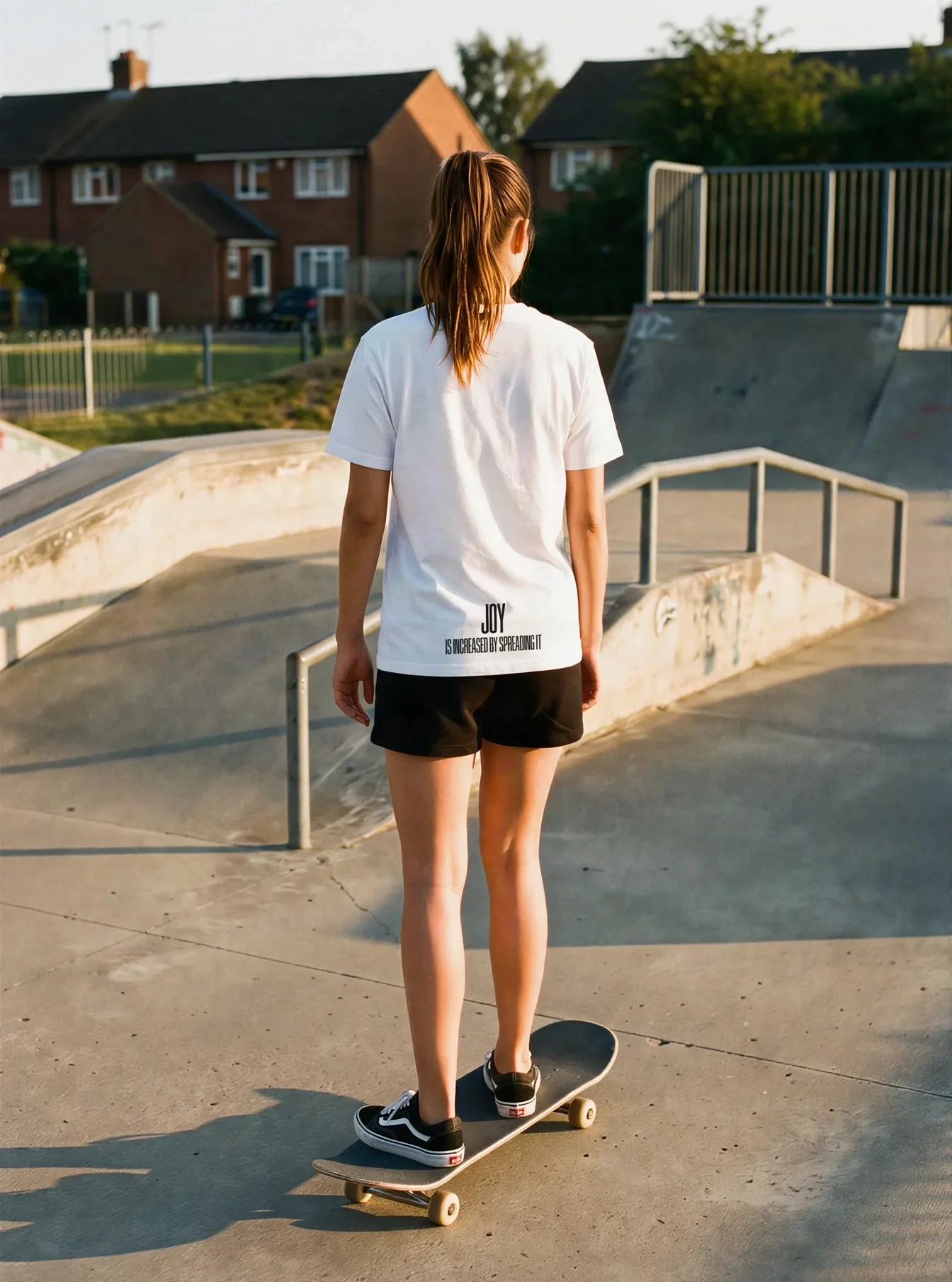 "JOY IS INCREASED BY SPREADING IT" Backprint Tee worn by a model