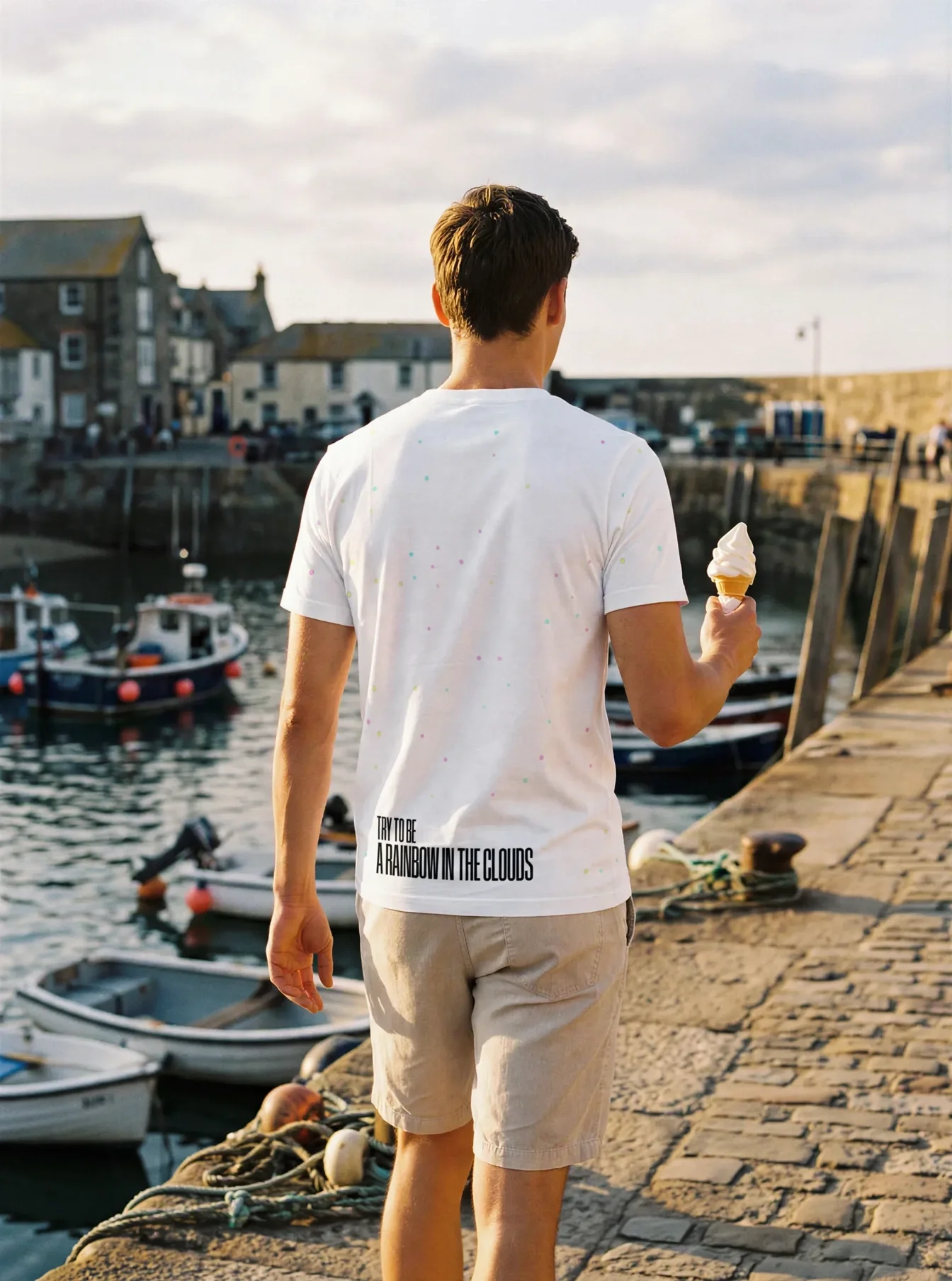 "Try to be a rainbow in the clouds" Backprint Tee worn by a model