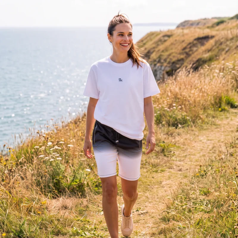 Lily wearing Its.That. Charcoal Dip Sweat Shorts with a white logo tee
