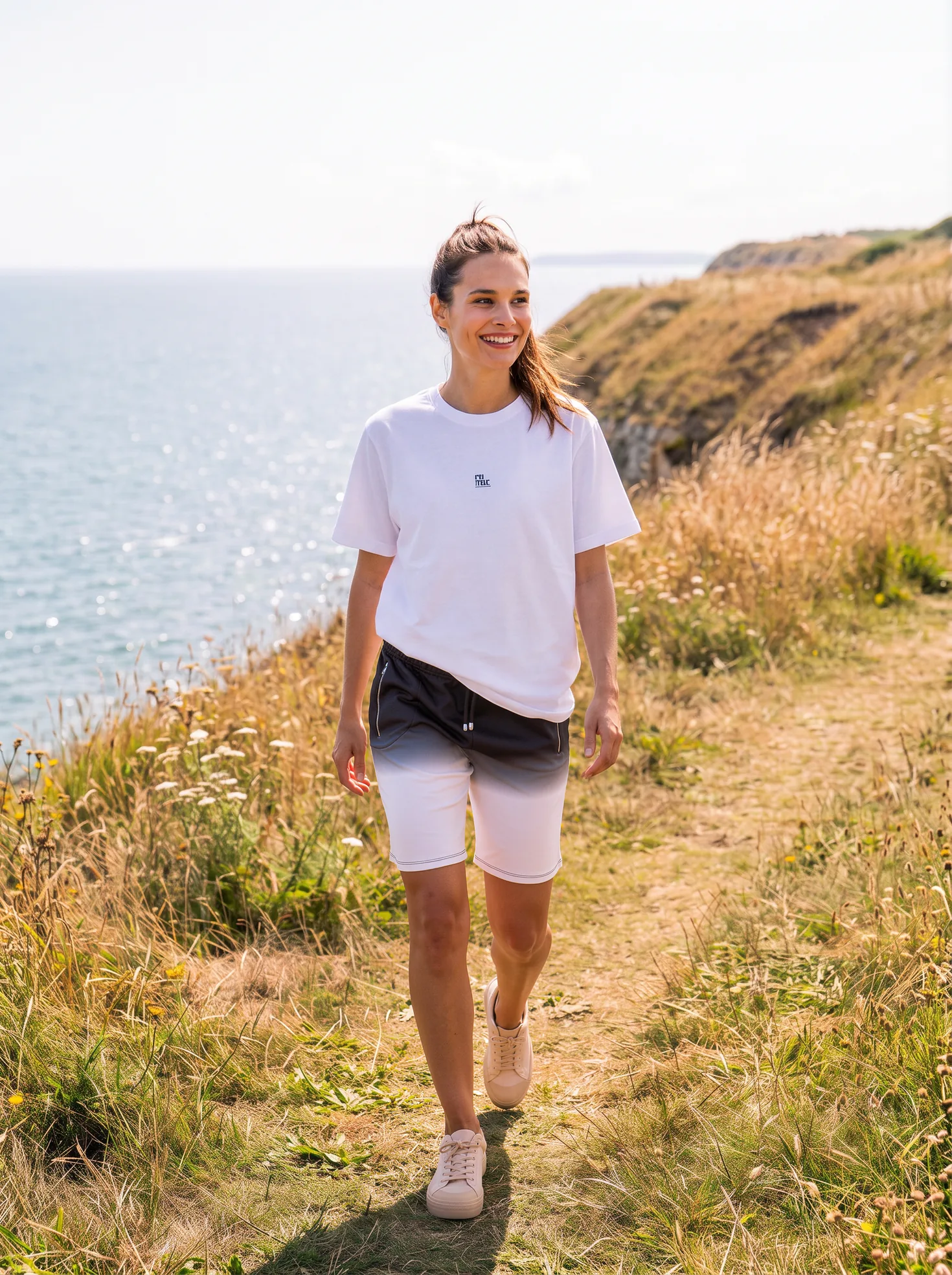 Lily wearing Its.That. Charcoal Dip Sweat Shorts with a white logo tee