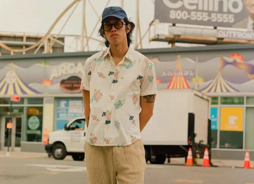 A person modelling layered streetwear against an urban backdrop, illustrating contemporary street-style fashion.